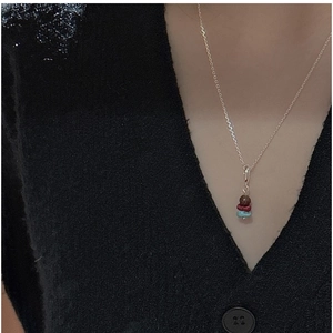 Close-up of S925 silver necklace with three multi-colored stone beads on a black knit top