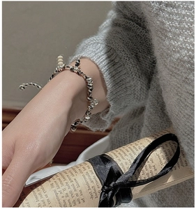 Close-up of S925 sterling silver braided bracelet with beads and heart charm on wrist