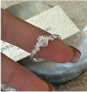 Detailed view of an S925 silver seashell ring with pearl textures worn on finger