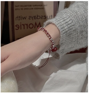 Detail of S925 sterling silver beads woven on a red cord bracelet with adjustable knot