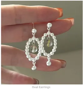 Détail de la boucle d'oreille ovale en perles d'argent avec une perle jaune translucide