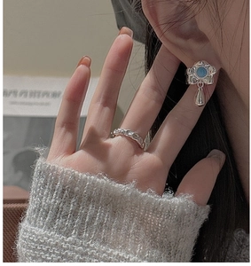 Detail of S925 silver turquoise earring and hammered ring worn with a grey knit sweater