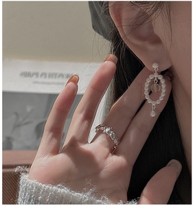 Détail d'une bague en argent S925 texturée et de boucles d'oreilles perles sur modèle