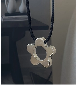 Detail of silver S925 floral pendant with glossy finish on a minimalist black cord