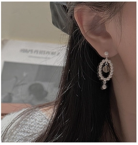 Gros plan de boucles d'oreilles en argent S925 avec perles et perle ambre unique