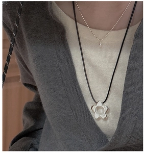 Detail of layered S925 sterling silver flower pendant with black cord and bead chain