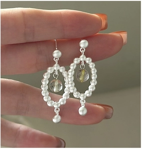 Détail de boucles d'oreilles en argent S925 avec perles mates et charm en cristal