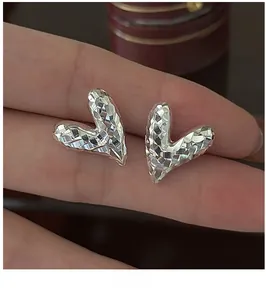 Vue macro détaillée des boucles d'oreilles cœur en argent S925 avec facettes CNC