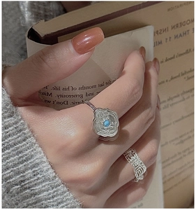 Detailed shot of retro silver ring with turquoise stone and relief pattern on model hand