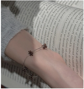 Detail of S925 sterling silver bracelet with brown beaded flowers on model wrist