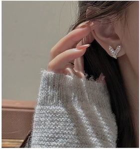 Gros plan de boucles d'oreilles cœur en argent S925 avec finition CNC sur un modèle