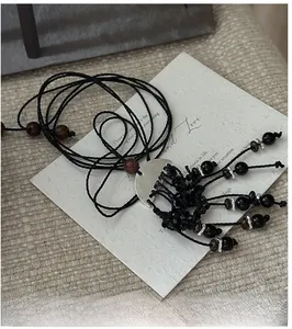 Détail du collier à glands noirs fait main avec accents argentés et perles de bois