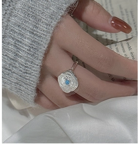 Detailed shot of S925 silver vintage turquoise ring with wavy flower texture and blue gem