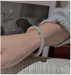 Détail d'un élégant bracelet en perles avec boucle en cristal sur fond vintage chic