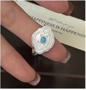 Detail of vintage silver ring with turquoise stone and ornate wavy textured engraving