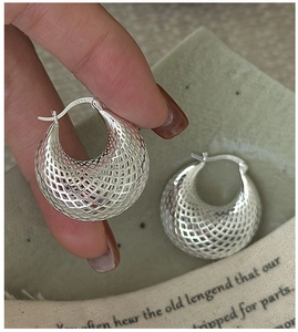 Détail macro des boucles d'oreilles en argent S925 avec maille ajourée et effet 3D