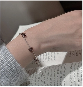 Detailed shot of beaded flower bracelet with silver tube accents on a vintage book