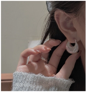 Gros plan de boucles d'oreilles en argent S925 ajourées avec un motif maille rétro