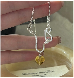 Detailed close-up of S925 silver necklace featuring matte curved pendant and yellow crystal