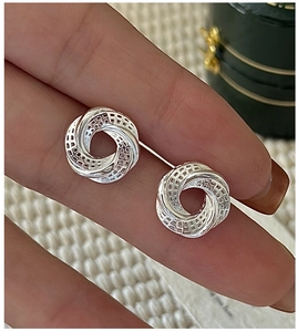 Detailed macro view of S925 sterling silver hollow twisted hoop earrings with grid pattern