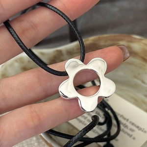 S925 sterling silver five-petal flower pendant on black cord necklace held by hand