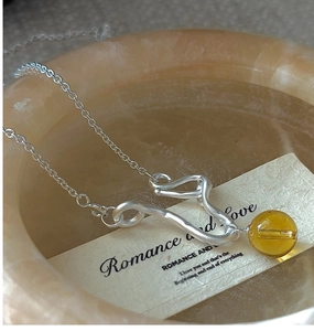 Close-up of S925 sterling silver necklace with wave bar and yellow citrine bead