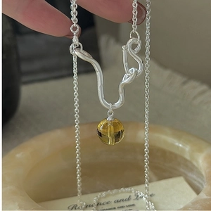 Macro detail of S925 sterling silver necklace with yellow crystal drop pendant
