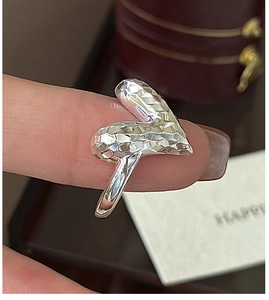 Detail of V-shaped sterling silver ring with CNC faceted texture on finger