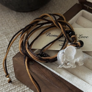 S925 sterling silver elephant necklace with brushed texture on a brown woven cord