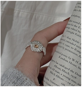 Detailed view of an S925 sterling silver sunflower ring with a yellow crystal on knits