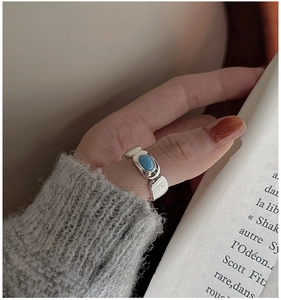 Detail of vintage S925 silver ring with blue turquoise stone on a soft knitted sleeve