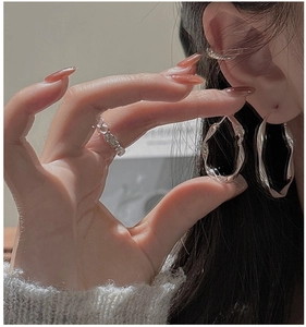 Macro detail of S925 silver wave earrings and cuff showing irregular handmade texture