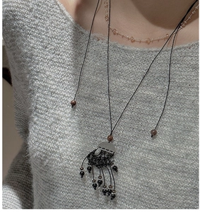 Détail du collier à franges en argent S925 avec chaîne à billes sur pull en tricot
