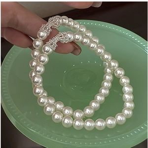 Détail du fermoir nœud argenté serti de strass sur bracelet en perles