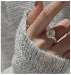 Detailed view of vintage S925 silver daisy ring with gold center and hammered texture band