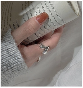 Macro shot of V-shaped hammered silver ring with lava texture against French magazine