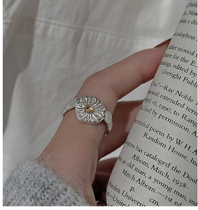 Detailed view of S925 silver daisy ring with yellow crystal on a wavy textured band