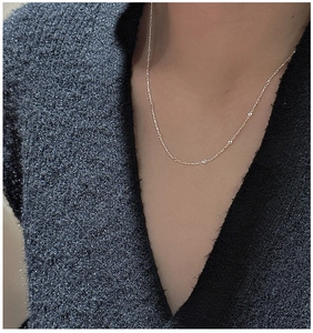 Close-up of a minimalist S925 sterling silver chain necklace on a model's neck