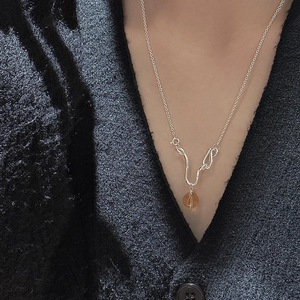 S925 sterling silver necklace with amber crystal pendant on a black knit cardigan
