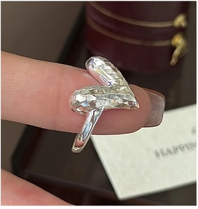 Close-up of S925 sterling silver heart ring with CNC faceted texture worn on finger