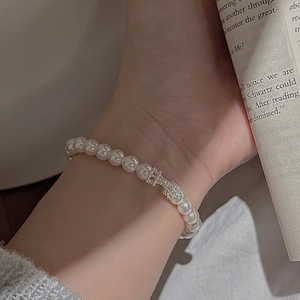 Bracelet élégant en argent S925 avec perles et breloque noeud sur le poignet d'un modèle