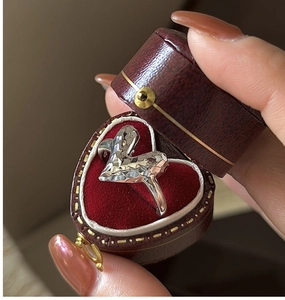 Macro shot of geometric faceted heart silver ring in a vintage red velvet gift box