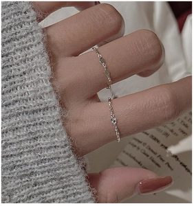 Close-up of S925 sterling silver minimalist rings worn on hand against a cozy backdrop