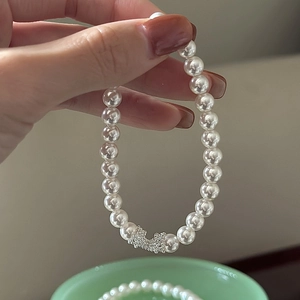 Bracelet en perles argent S925 avec breloque nœud en cristal étincelant sur la main