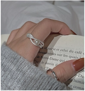 Dettaglio di un anello in argento S925 con perla bianca e texture in metallo spazzolato