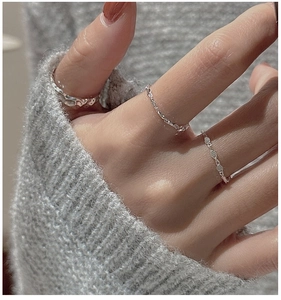Detail of silver S925 stackable ring set with lava texture and chain designs
