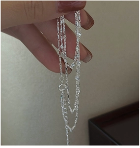 Macro detail of S925 sterling silver layered necklace with faceted beads and adjustable clasp