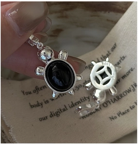 Vue détaillée du pendentif tortue en argent S925 avec pierre noire et poinçon S925