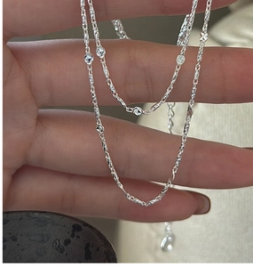 Macro shot of S925 sterling silver chain with faceted metal beads and twisted link detail