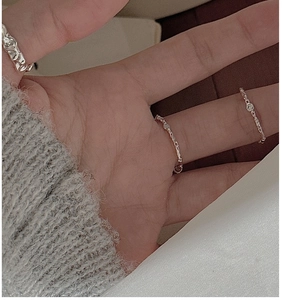 Detail of S925 sterling silver ring set featuring textured band and rope chain designs